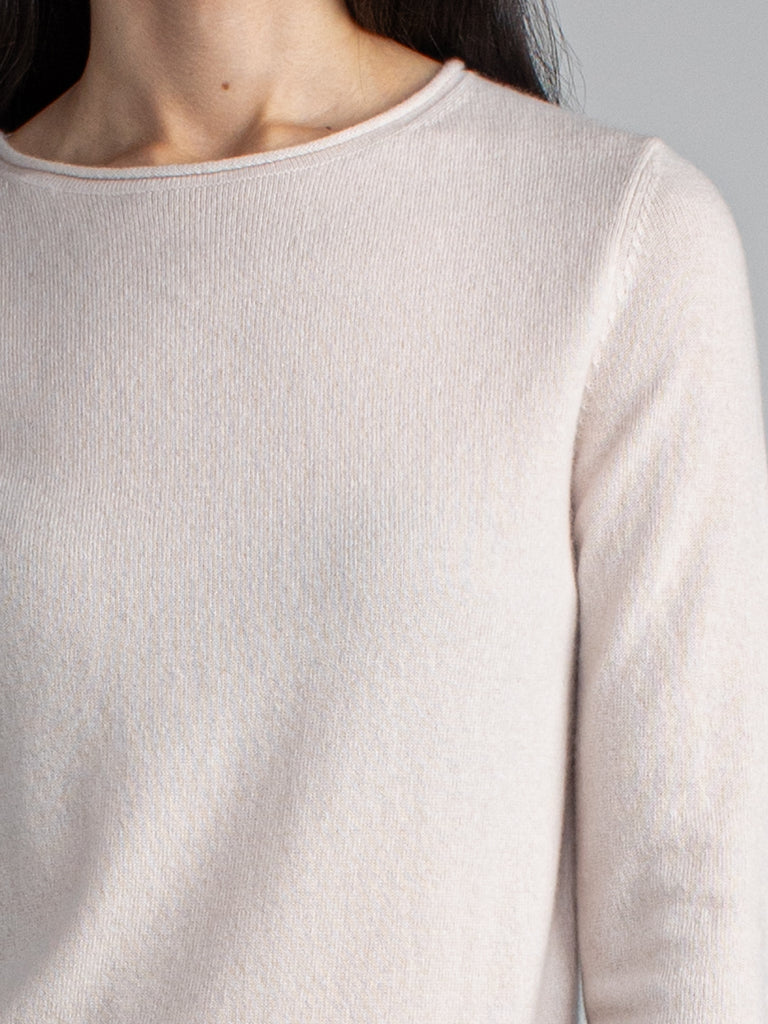 Woman wearing a pale pink cashmere tee.