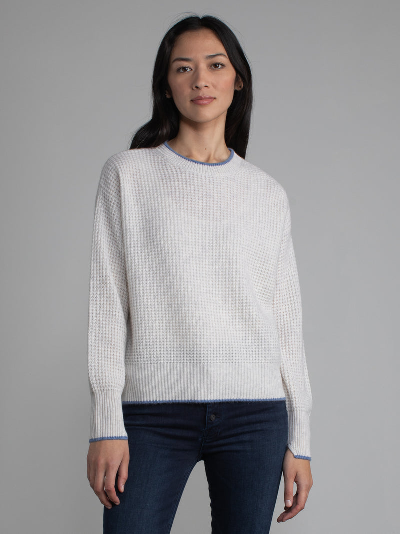 Female wearing white waffle stitched pullover.