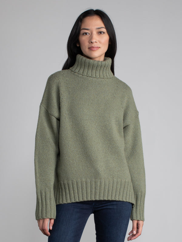 Woman wearing green turtleneck sweater.