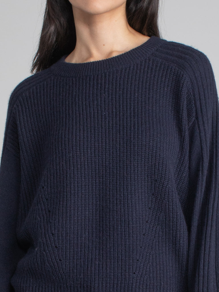 Woman wearing navy sweatshirt.