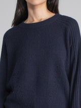 Woman wearing navy sweatshirt.