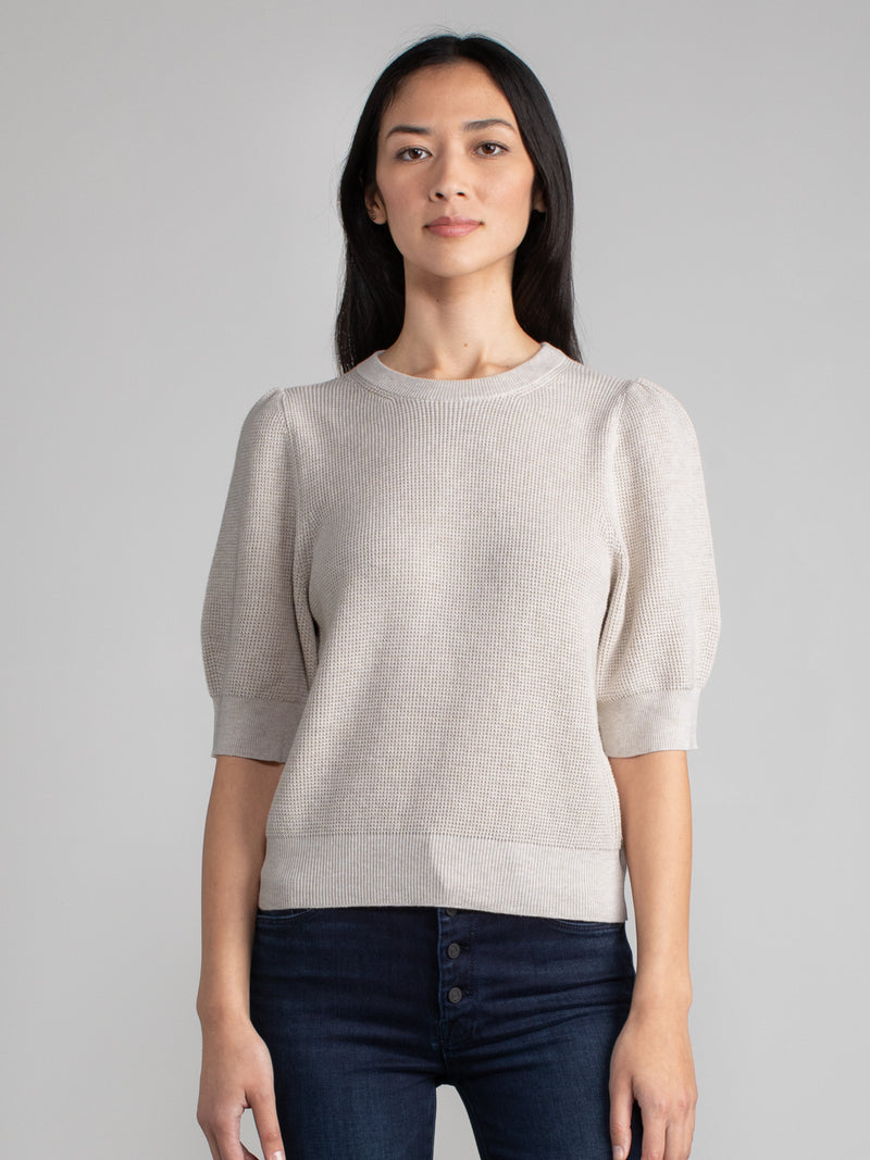 Woman wearing a oat-colored puff sleeve thermal tee.