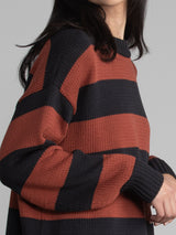 Women wearing an oversized striped sweater.