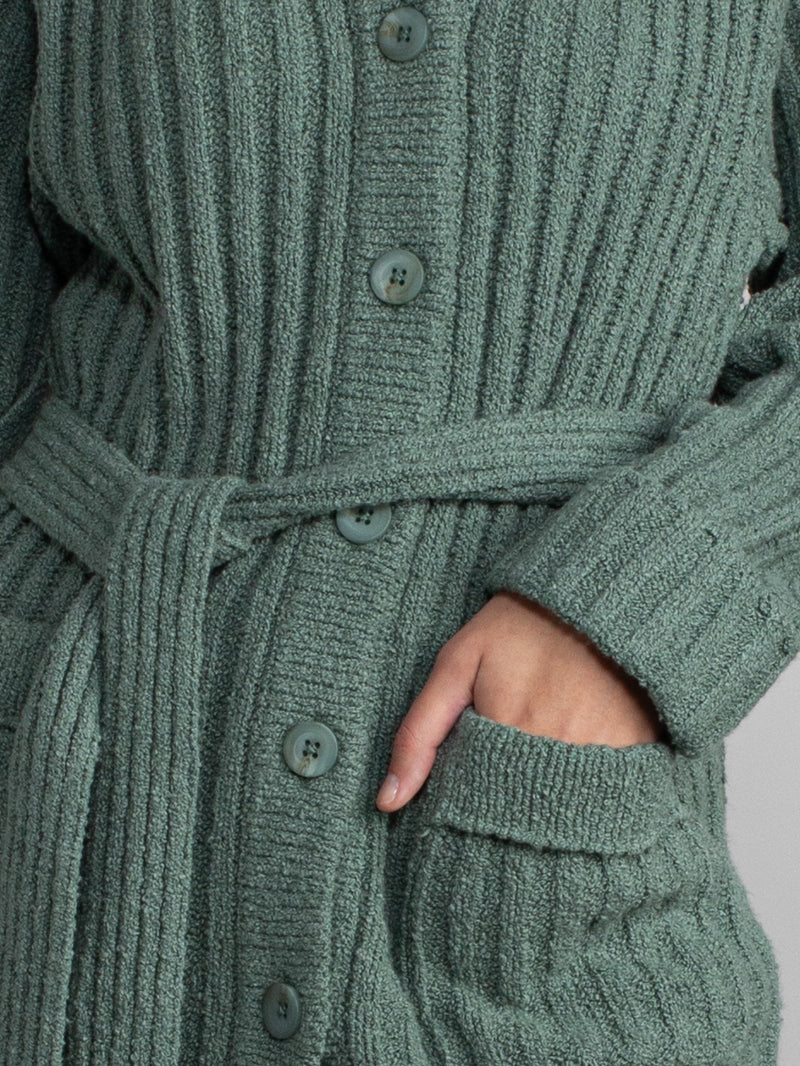 Woman wearing a green fleece button down jacket..
