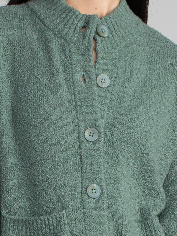 Woman wearing a green fleece cropped cardigan.