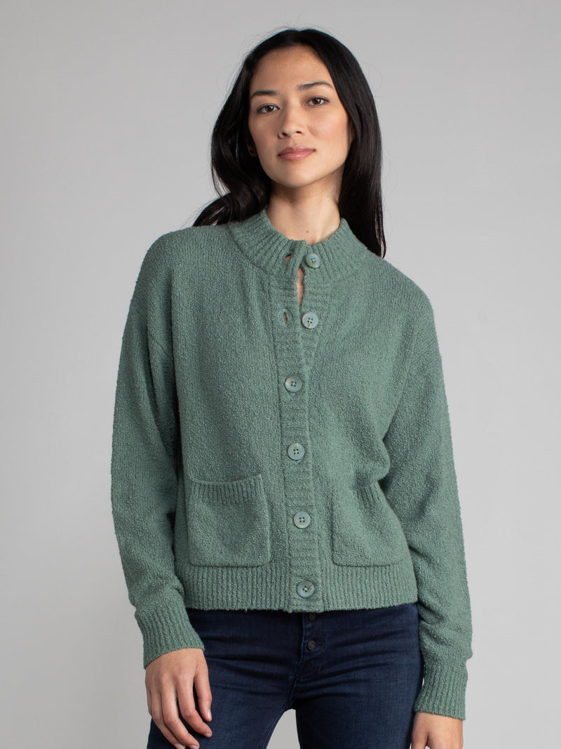 Woman wearing a green fleece cropped cardigan.