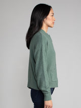 Woman wearing a green fleece cropped cardigan.