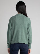 Woman wearing a green fleece cropped cardigan.