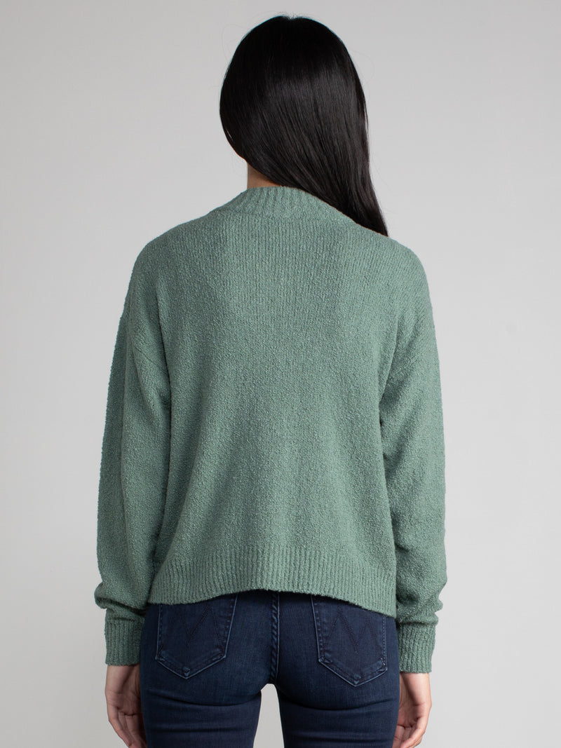 Woman wearing a green fleece cropped cardigan.