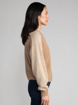 Woman wearing a carmel brown fleece sweater.