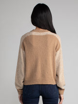 Woman wearing a carmel brown fleece sweater.