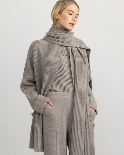 Woman wearing the Florence Coat, Ribbed Knit Scarf in risotto, Split Hem Pant in oat, and Plated T-Neck in sand marl made by Margaret O'Leary.