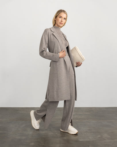 Woman wearing the City Coat, Split Hem Pant in oat, and Plated T-Neck in sand marl made by Margaret O'Leary.