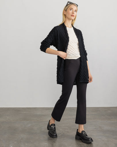 Woman wearing 3D Open Coat in black with the 3D Tee in white and the Cropped Flared Pant in black made by Margaret O'Leary.