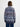 Woman wearing a Fairisle Coat by Margaret O’Leary, a navy knit cardigan coat with red, white, and blue fair isle pattern, shown on a plain background.