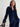 Woman wearing a blue velvet outfit against a plain background