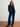 Woman wearing a navy velvet outfit on a plain background