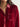 Close-up of a person wearing a cranberry velvet shirt with a plain background