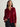 Woman wearing a cranberry velvet shirt against a plain background