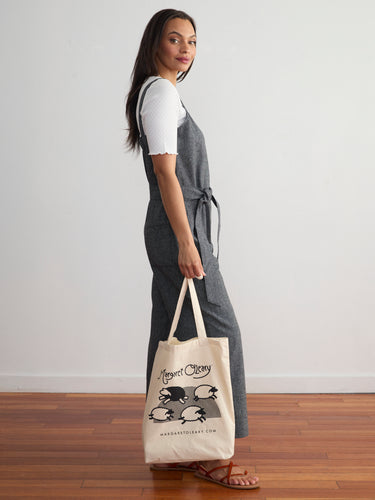 A canvas totebag featuring the Margaret O'Leary logo and an illustration of sheep leaping across a field.