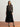 Woman wearing a dark sweater and black pleated skirt on a white background