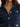 Close-up of a person wearing a dark blue textured jacket with gold buttons.