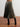 Person wearing a pleated metallic skirt on a wooden floor with a white wall background