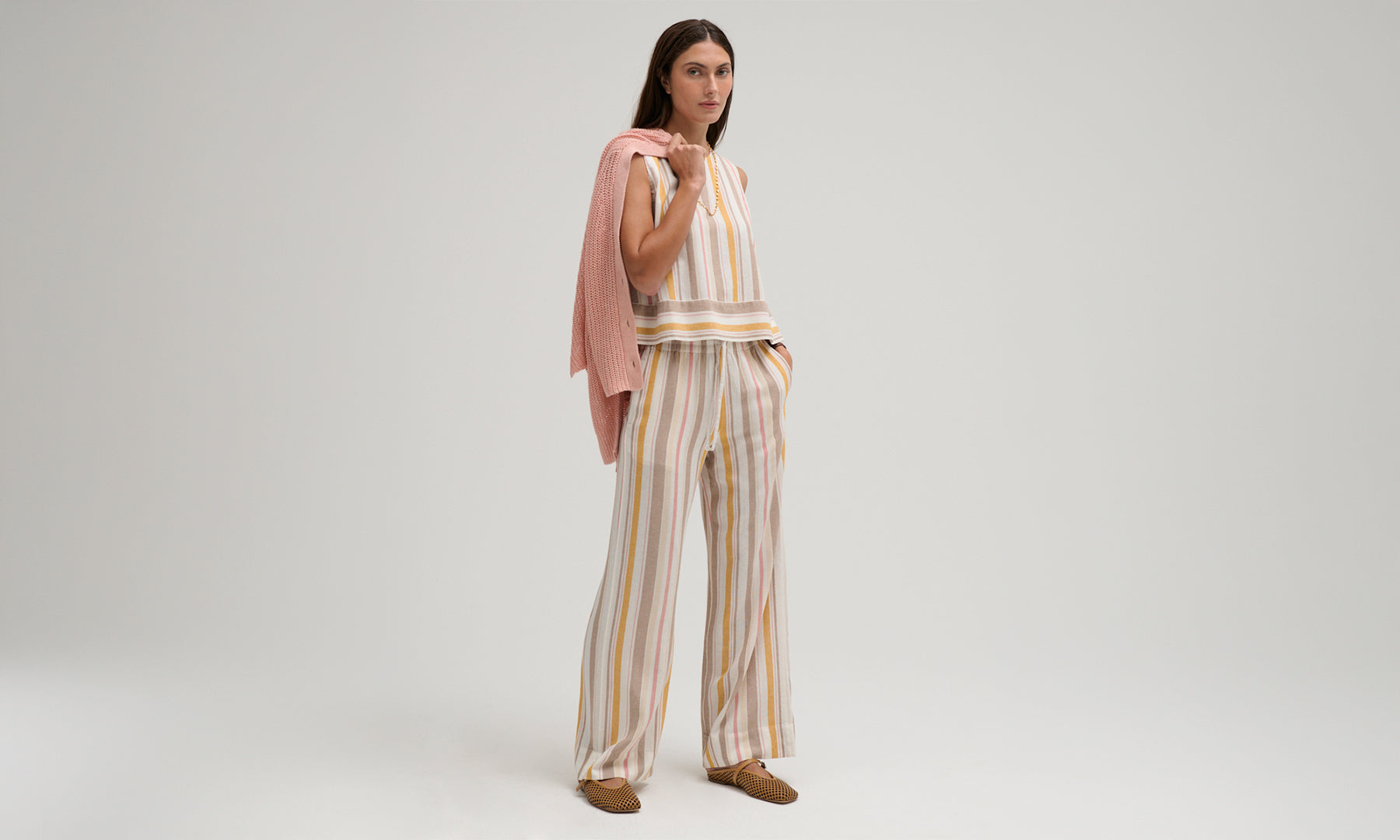 Woman wearing the Avery Button Back Tank and Vida Pant by Margaret O'Leary on a plain background