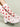 White shoes with red heart patterns on white socks against a light green background