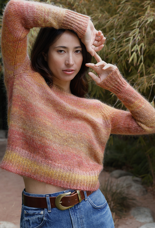 A woman wearing the orange Marina Pullover sweater.