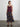 Woman wearing a Natalya Pleated Skirt by Margaret O’Leary, a multicolour plaid pleated skirt styled with a burgundy silk cami on a plain background.