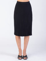 Model wearing a pleated black skirt.