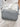Gray woven crossbody bag by Sol & Selene worn by a person in light clothing