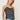 Woman wearing a Lace Silk Cami by Margaret O’Leary, a black silk camisole with lace trim and white line print on a plain background.