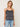 Woman wearing a Lace Silk Cami by Margaret O’Leary, a black silk camisole with lace trim and white line print on a plain background.