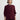 Woman wearing a maroon Diedre Cable Pullover Sweater by Margaret O'Leary over a white shirt on a plain background