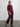 Woman wearing a maroon Diedre Cable Pullover Sweater by Margaret O'Leary over a white shirt on a plain background