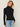 Person wearing the Dimensional Neck, a black tneck textured sweater by Margaret O'Leary paired with blue jeans.