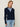 Woman wearing the Fitted Cashmere Hoodie, a navy zip-up hoodie by Margaret O'Leary over a stripe shirt with light blue jeans on a plain background