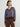 Person wearing the Jacquard Vee, a brown and blue patterned sweater by Margaret O'Leary paired with brown pants