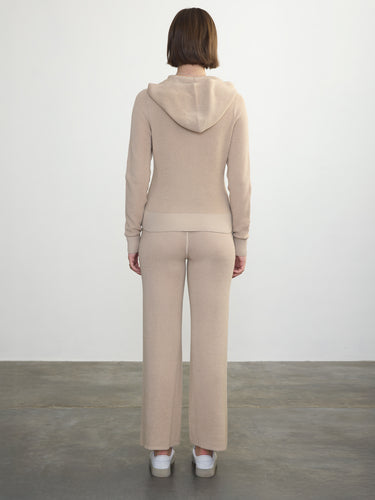 Person wearing the Joan Waffle Pant, a beige waffle knit pant by Margaret O'Leary paired with a matching hoodie 