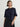 Person wearing the Lola Pullover, a blue and black boucle pullover by Margaret O'Leary paired with a black pleated skirt.