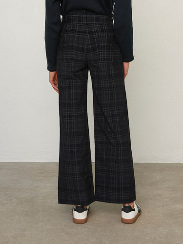 Back view of a person wearing the Parker Pant, a black corduroy plaid pant by Margaret O'Leary.