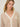 Person wearing the Santa Rosa Cardi a beige cardigan with white accents by Margaret O'Leary.