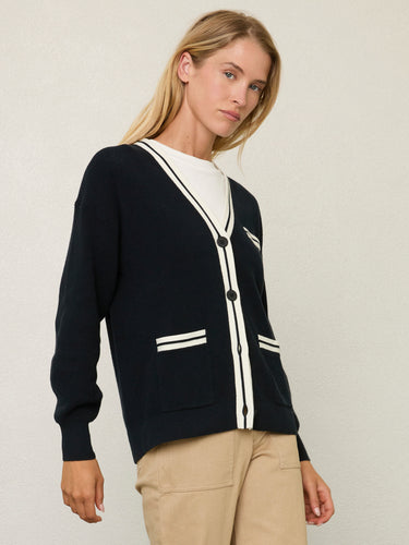 Person wearing the Santa Rosa Cardi a black cardigan with white accents by Margaret O'Leary paired with khaki pants