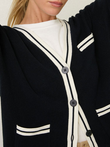 Person wearing the Santa Rosa Cardi a black cardigan with white accents by Margaret O'Leary paired with khaki pants