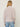 Person wearing the Tahoe Zip Up, a beige tneck cashmere zip up by Margaret O'Leary paired with blue jeans.