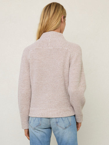 Person wearing the Tahoe Zip Up, a beige tneck cashmere zip up by Margaret O'Leary paired with blue jeans.