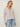 Person wearing the Tahoe Zip Up, a beige tneck cashmere zip up by Margaret O'Leary paired with blue jeans.