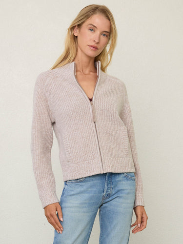 Person wearing the Tahoe Zip Up, a beige tneck cashmere zip up by Margaret O'Leary paired with blue jeans.